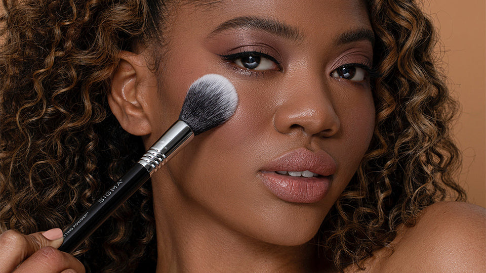 Applying face makeup with a Sigma Beauty brush