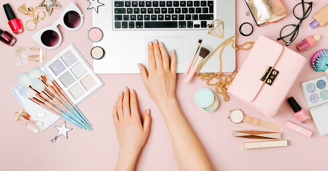 A woman using a laptop or smartphone with beauty products surrounding her