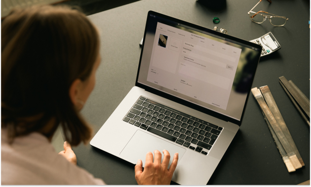 eCommerce marketer reviewing customer and product data on a laptop.