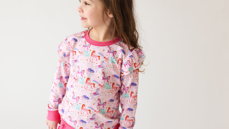 Toddler wearing pink unicorn-print bamboo pajamas from Autumn Moon Kids’ Clothing